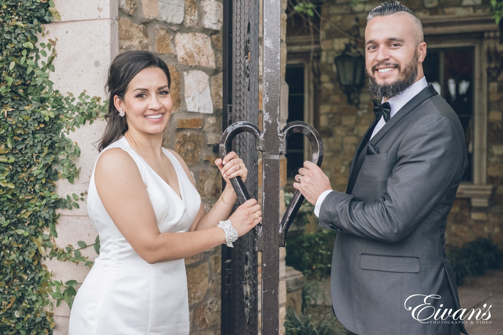 married man and woman standing next to a rusty gate