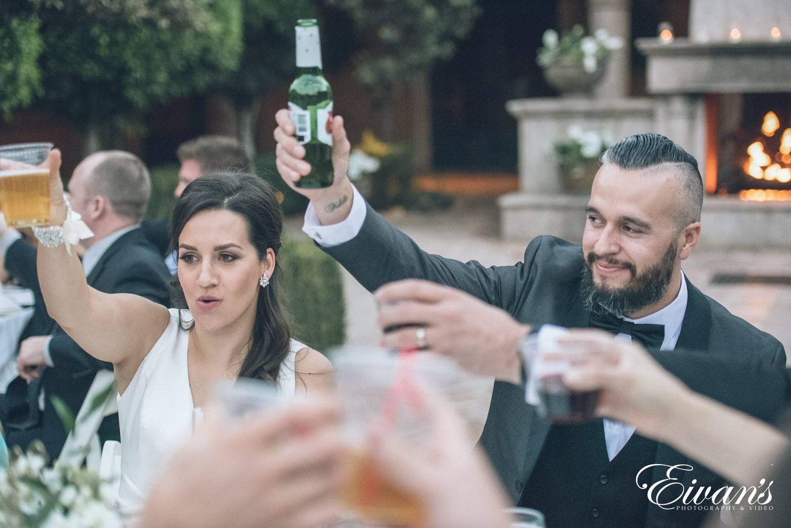 married man and woman holding their hands up with beer