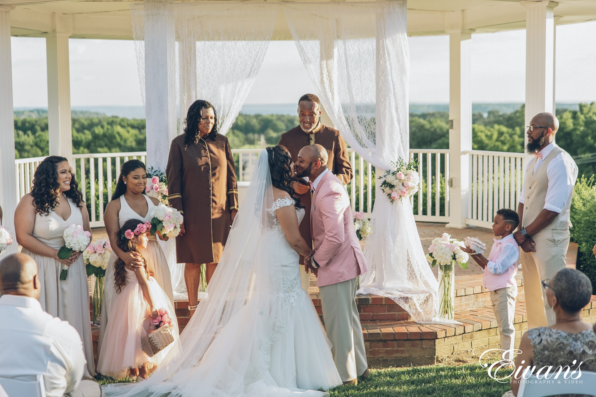 bride and groom sitting on green grass field during daytime