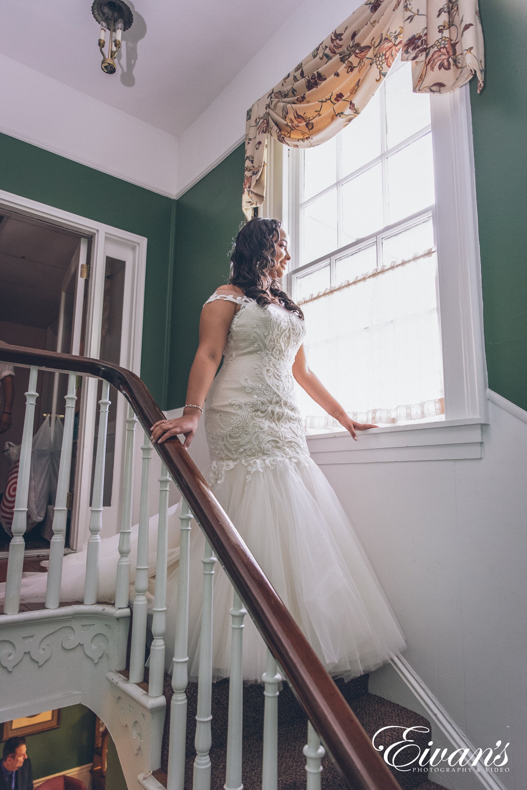 woman in white wedding dress standing on staircase