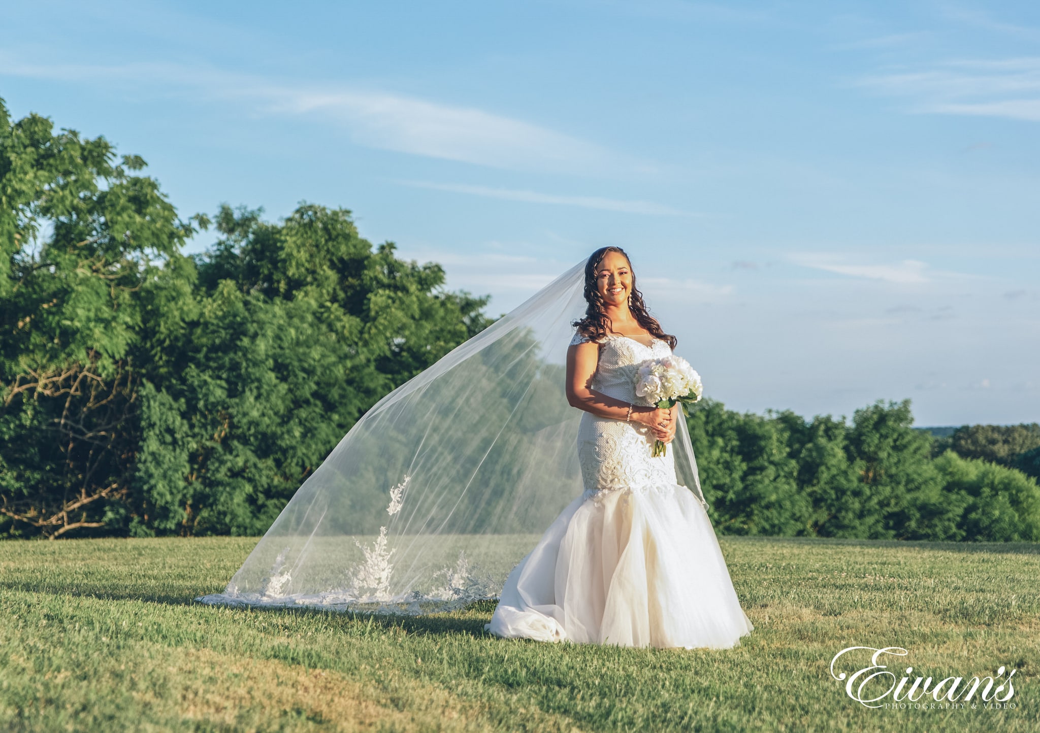woman in white wedding dress standing on green grass field during daytime