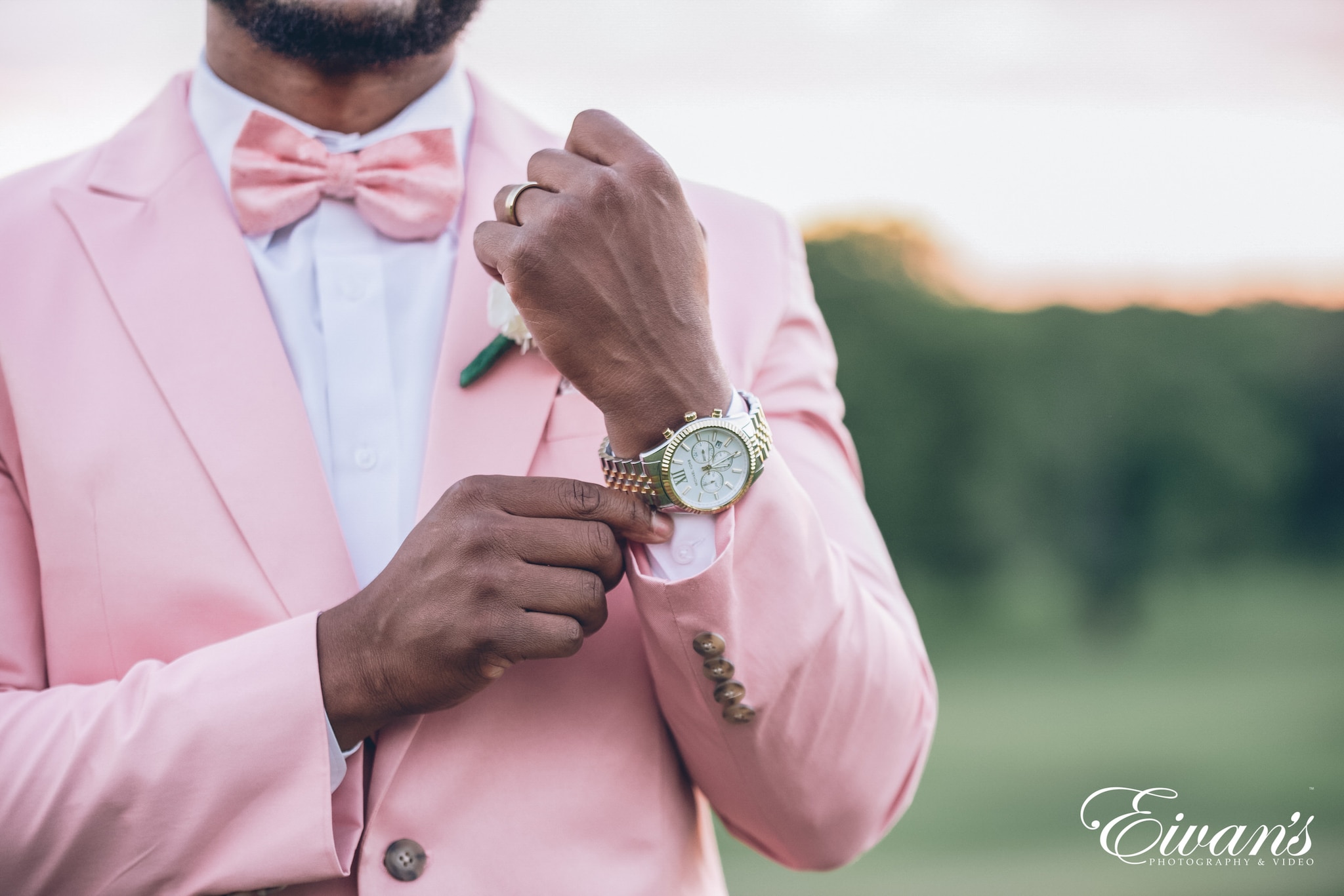 man in pink dress shirt wearing gold round analog watch