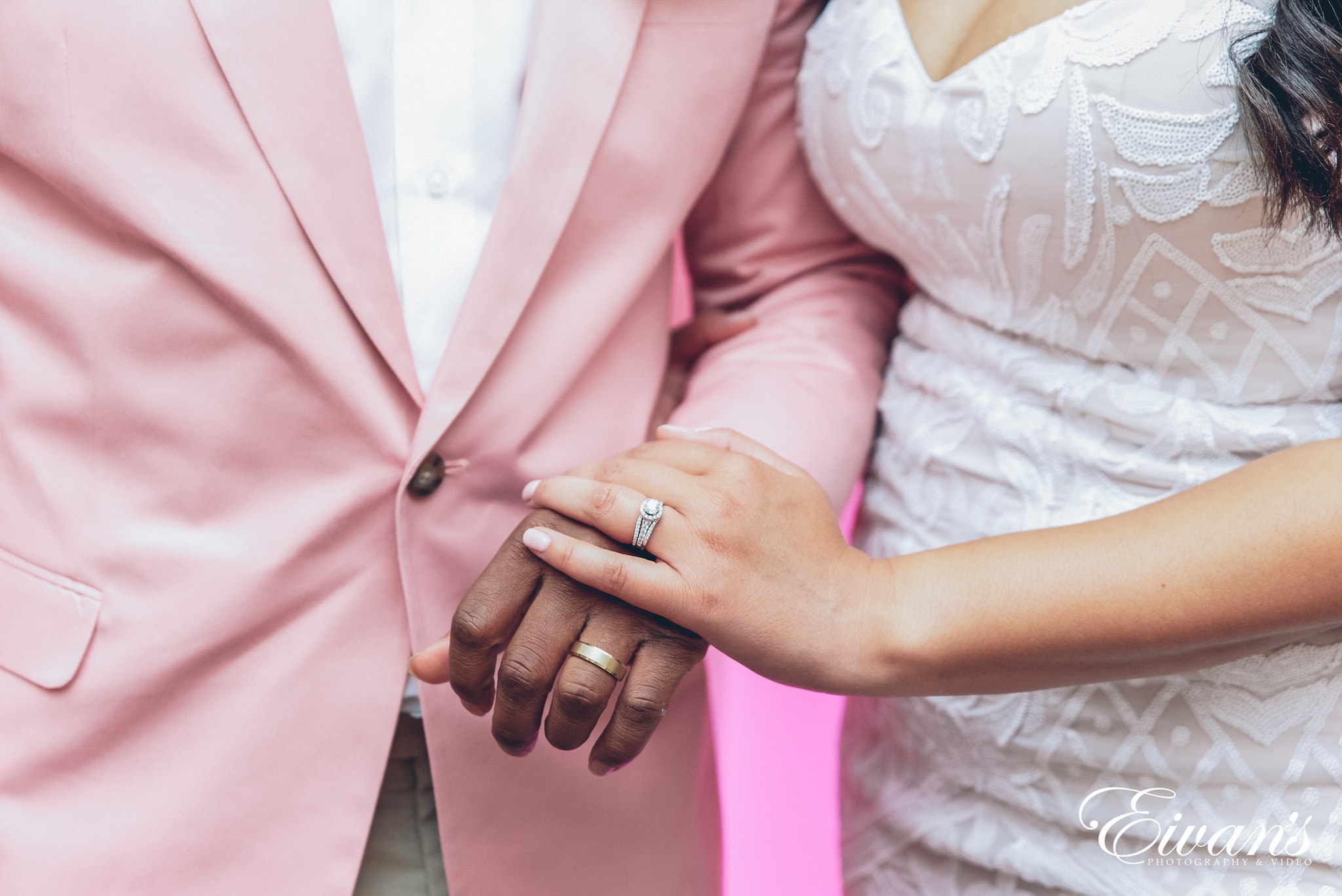 man and woman holding hands and showing off rings