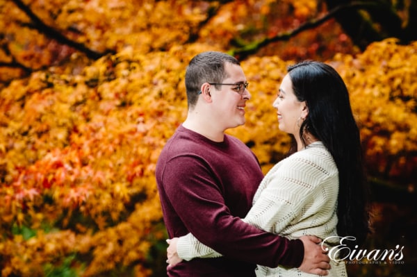 couple embracing each other during beautiful autumn color leaves