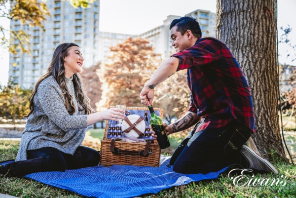 couple having a picnic at a state park while taking a candid engagement photo