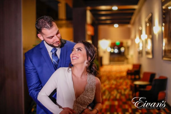 couple in a hotel lobby posing for a engagement photographer