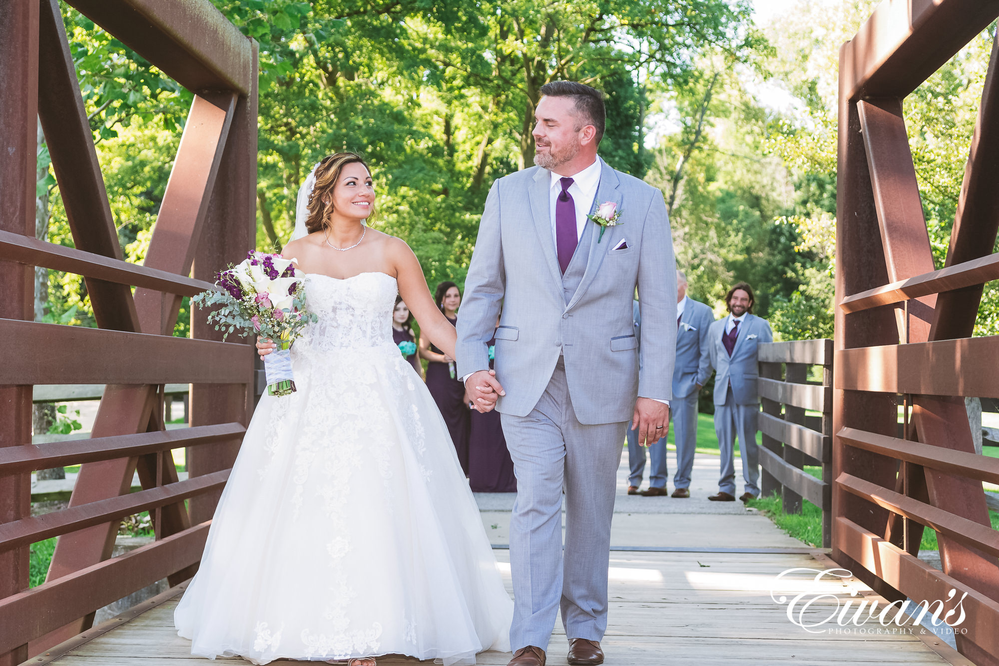 man in gray suit and woman in white wedding dress walking on sidewalk during daytime