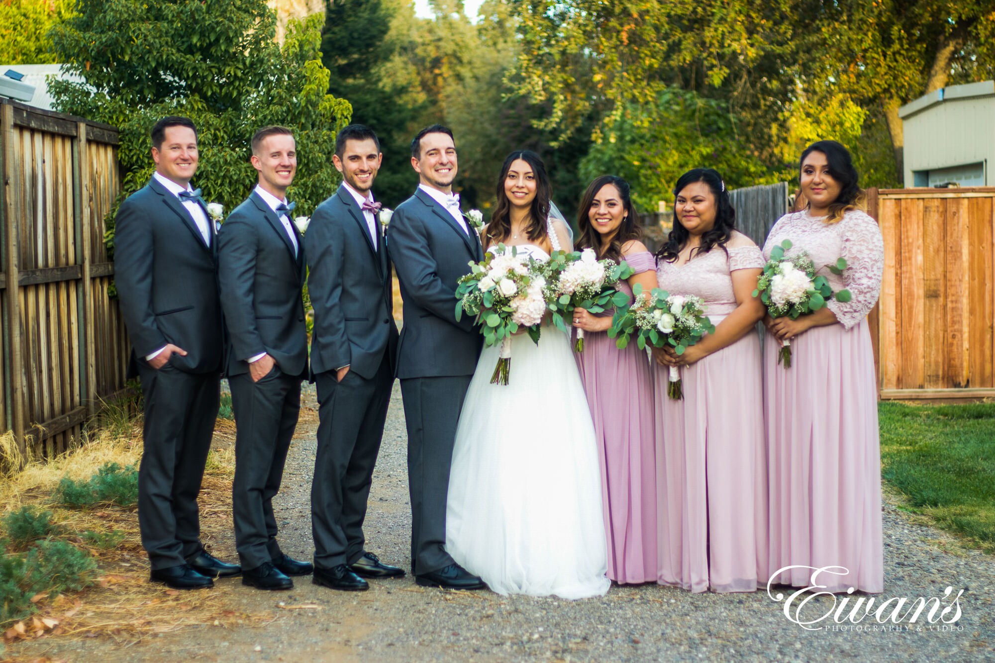 man in black suit standing beside woman in white wedding dress holding bouquet of flowers