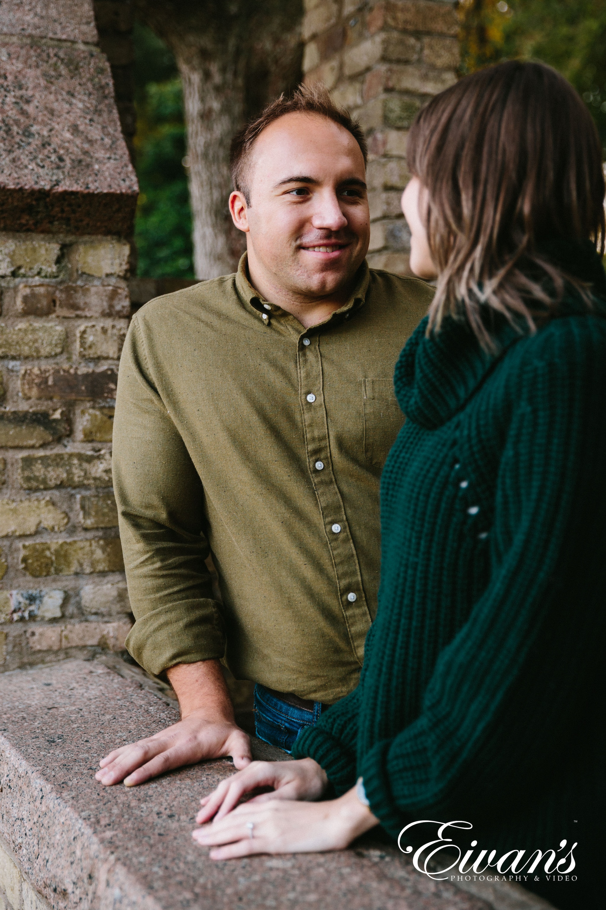 engaged couple wearing green pose for a photoshoot