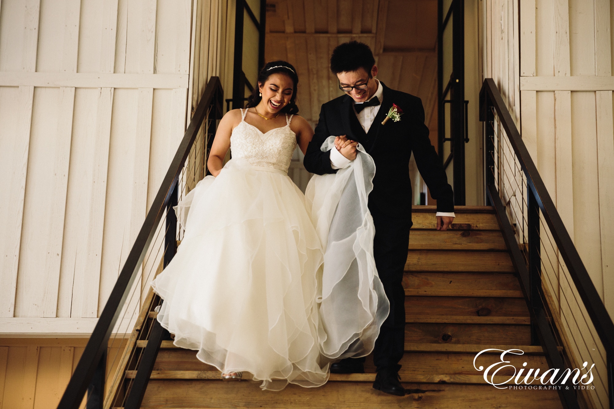 newly married couple walking down the barn stairs