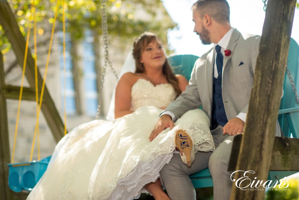 barn-wedding-photos married couple on a blue wooden swing