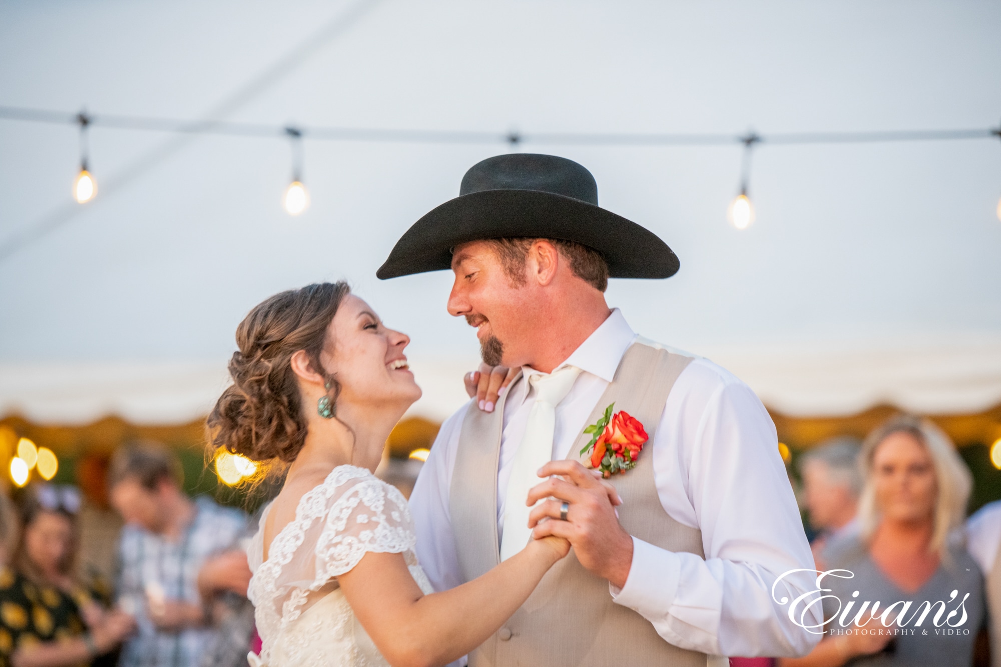 married couple dancing under string lights