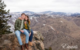 engaged couple posed on a cliff