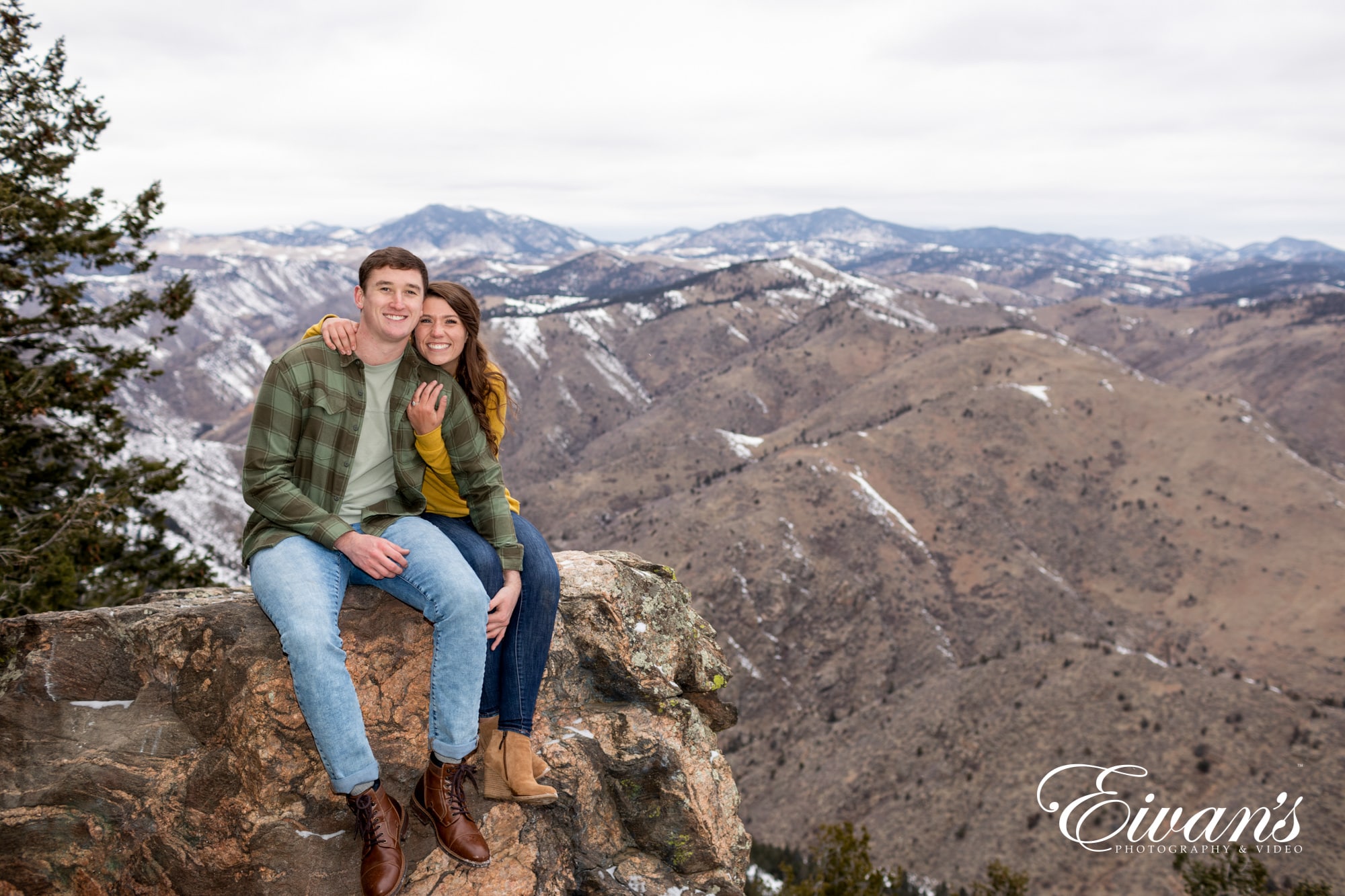 engaged couple posed on a cliff