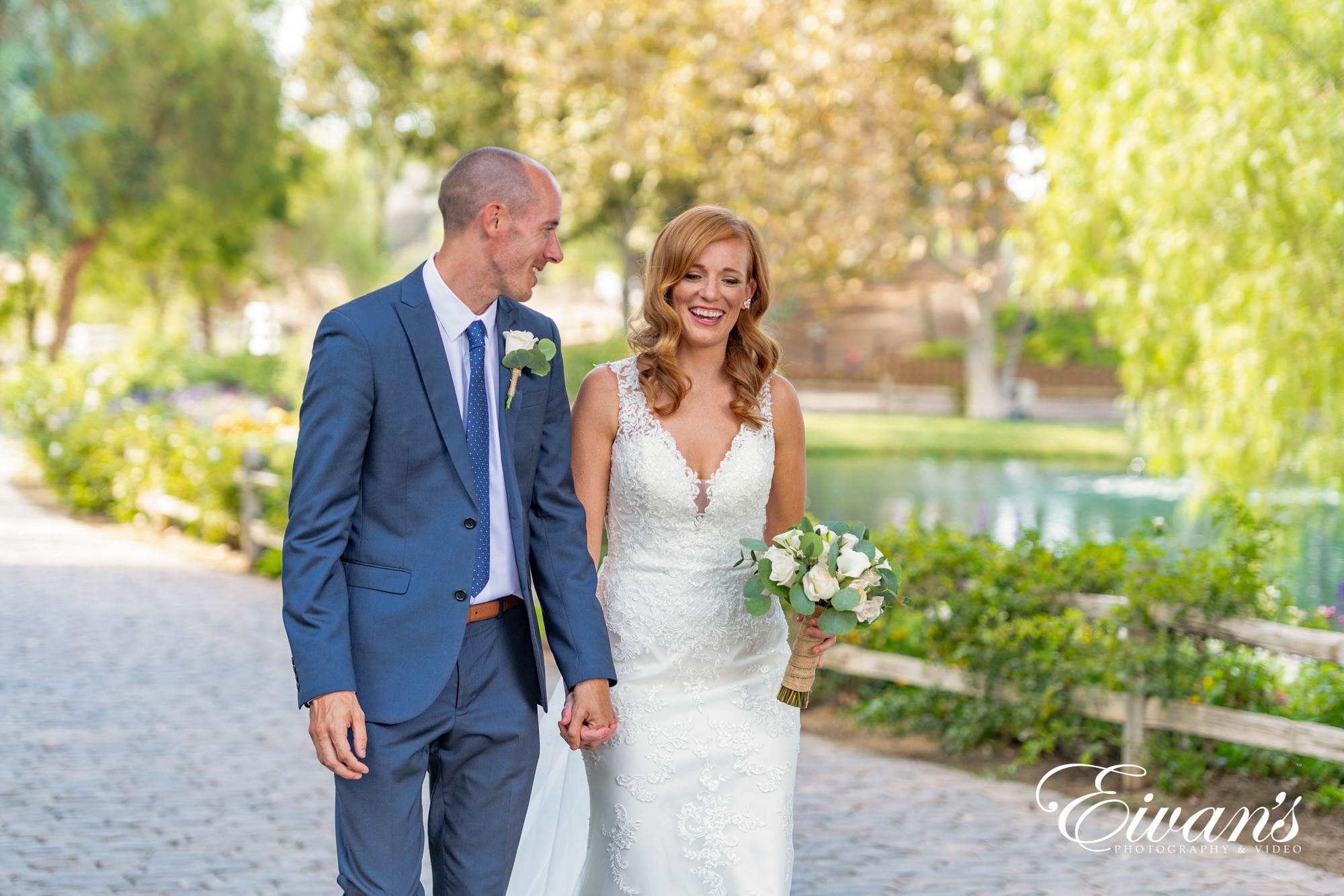 bride and groom walking beside each other in a park