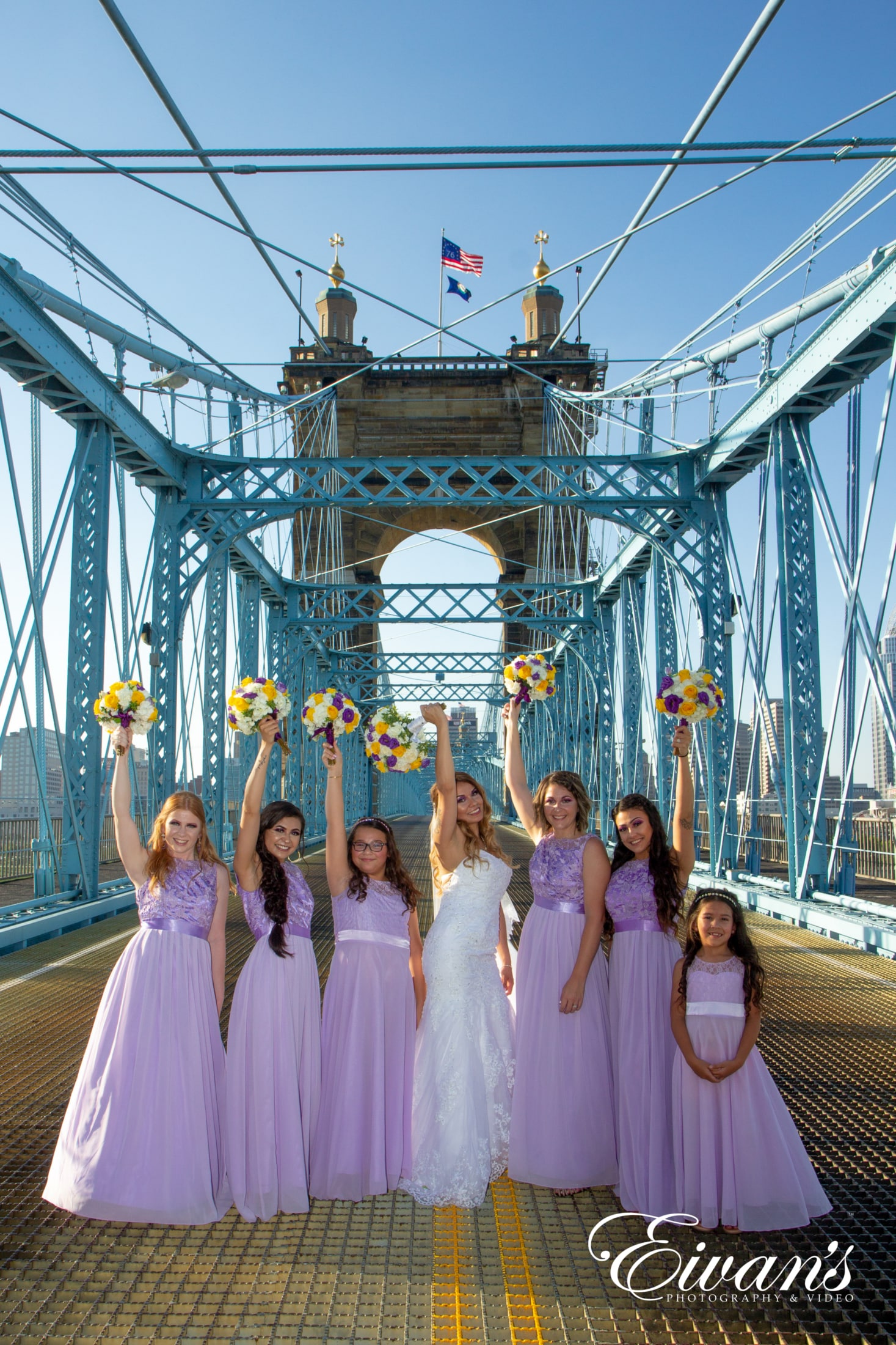 an image of a bride and her bridesmaids on the bridge