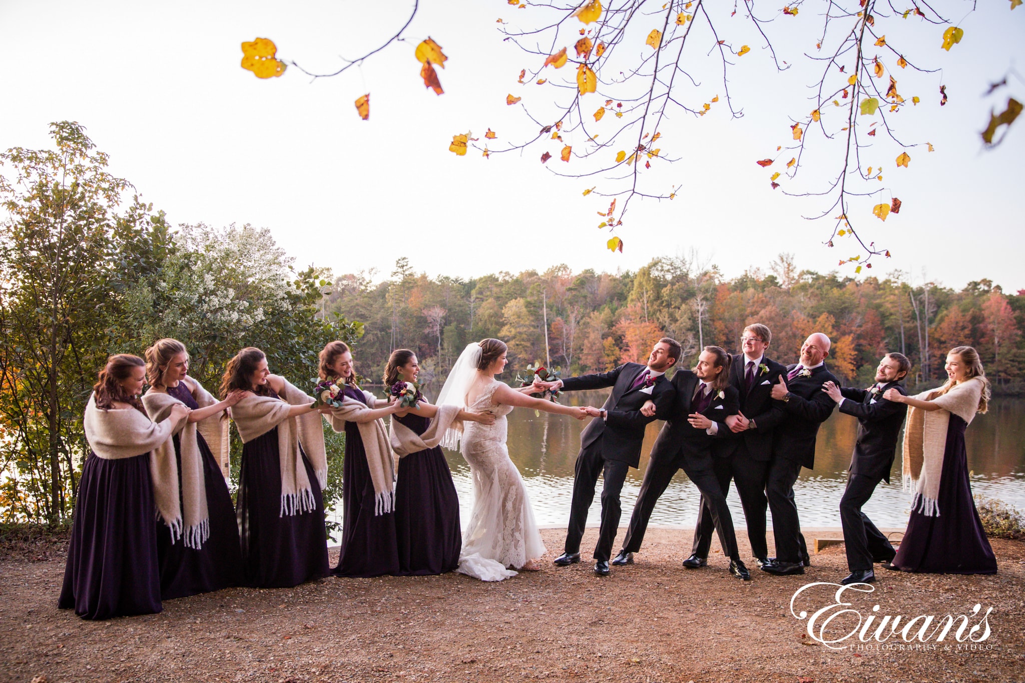 image of wedding party playing tug of war with the newlyweds