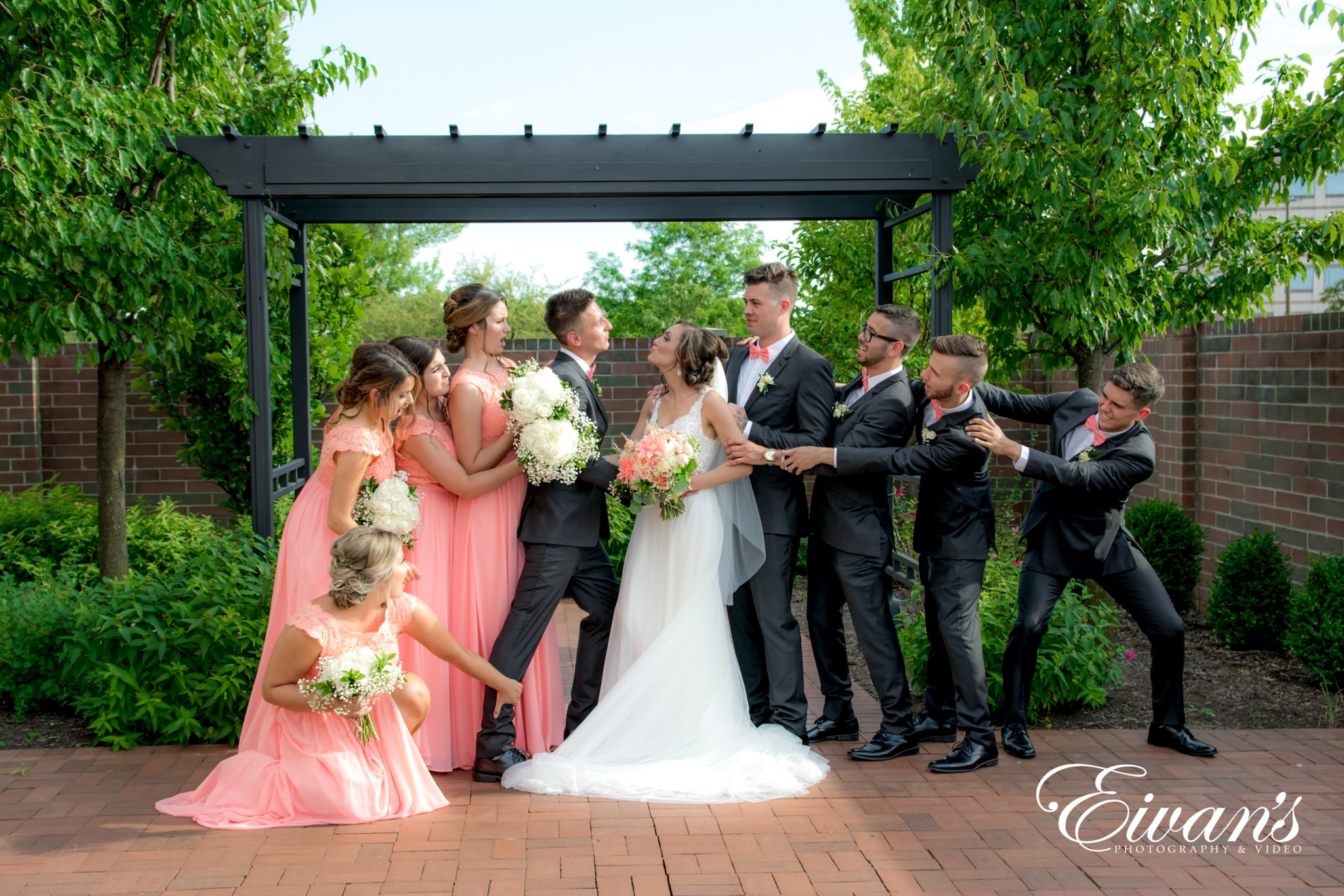 image of a wedding party posed like tog of war