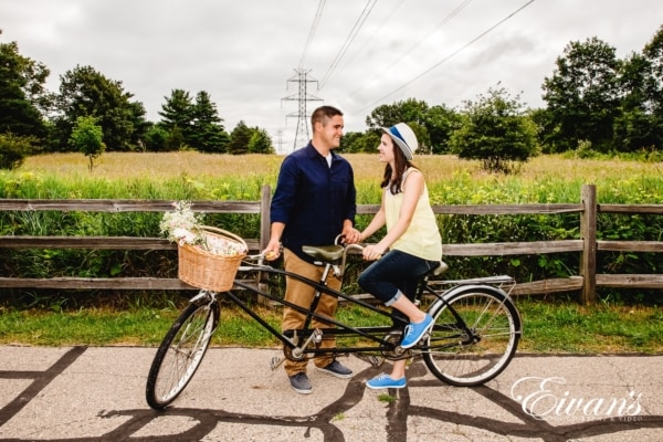 Image of an engaged man and woman on a two person bike