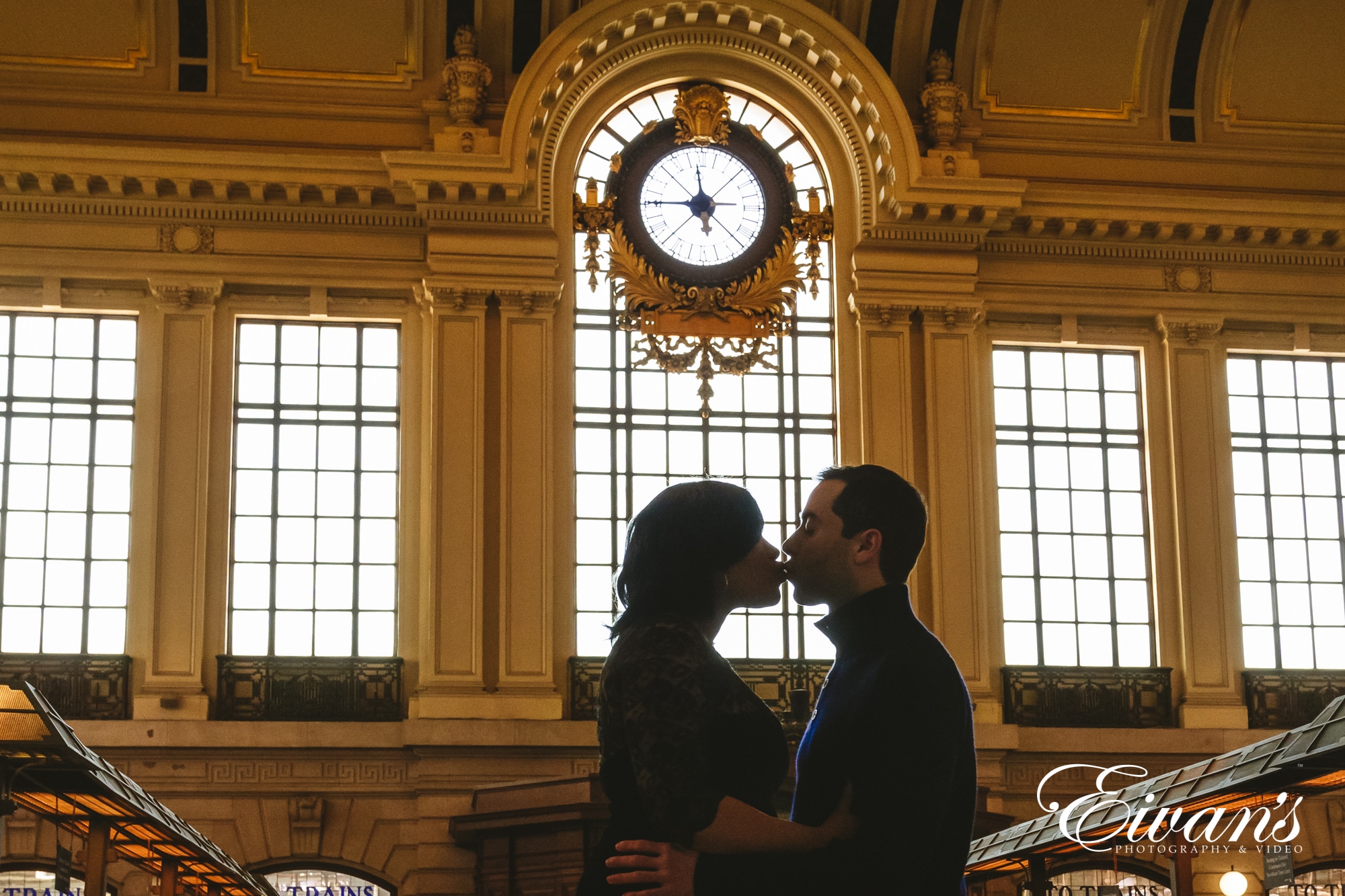 cute-engagement-photos Image of a man and woman kissing in the train station