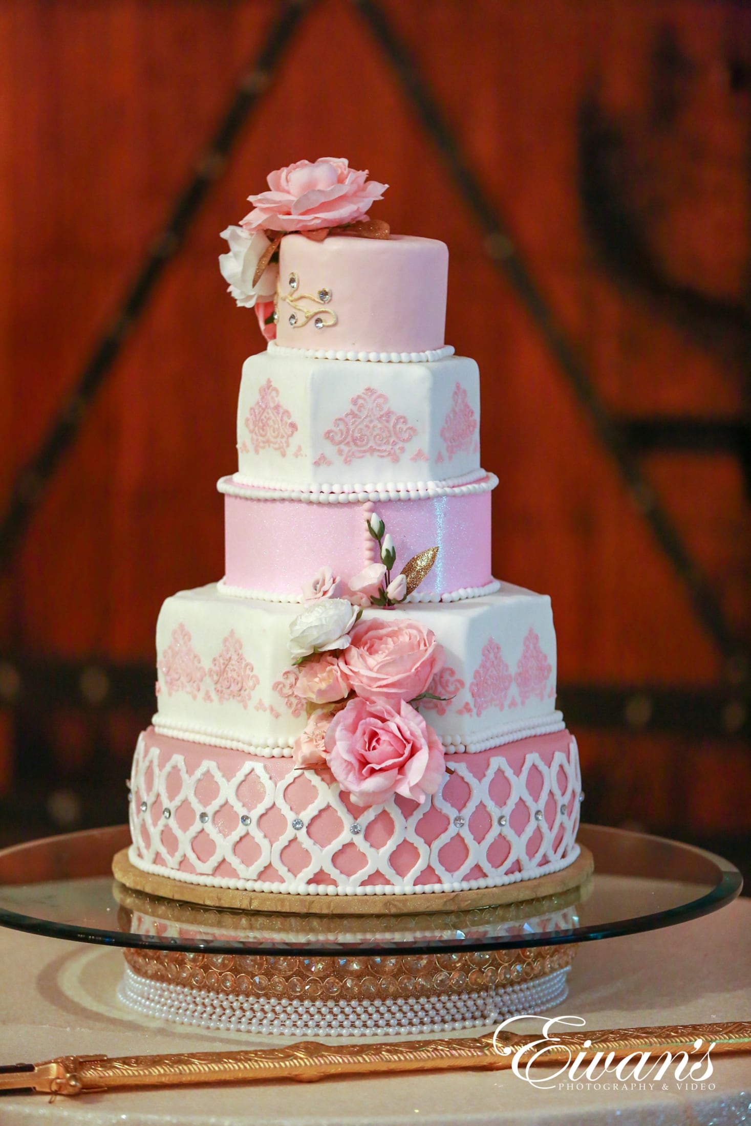 image of a five teared cake of pink and white