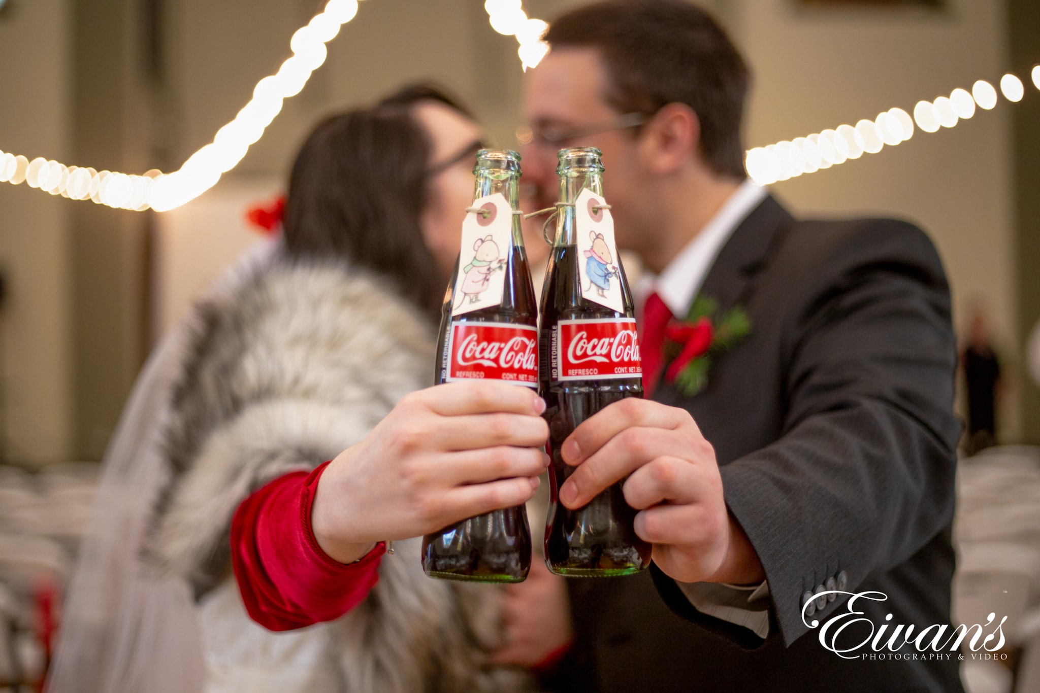 image of engaged couple kissing and cheering a coke