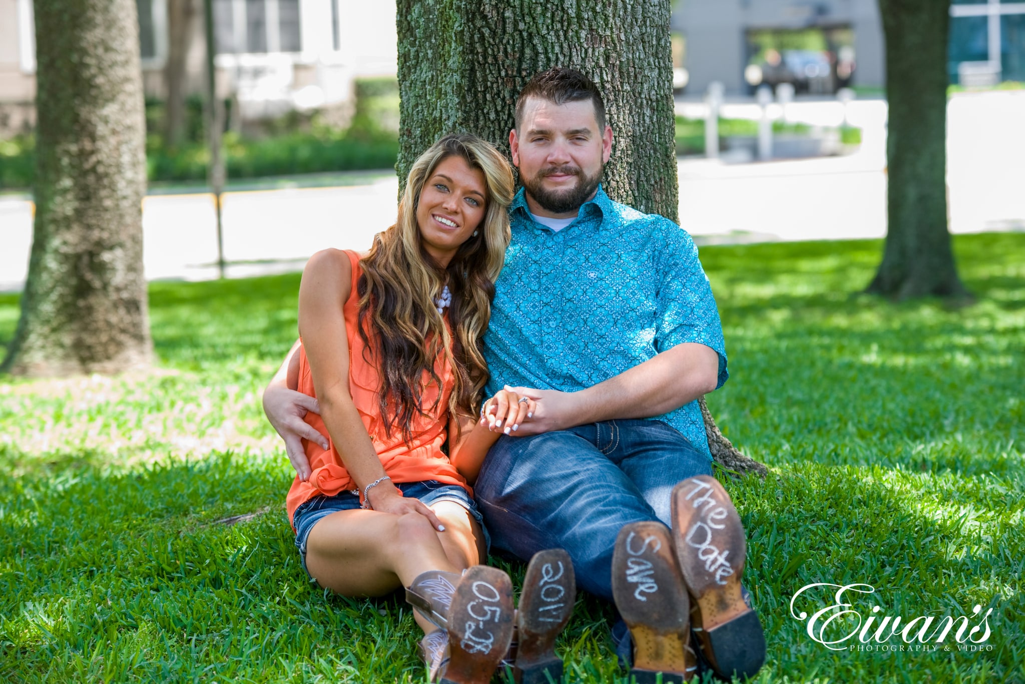 what-to-wear-for-summer-engagement-photos image of engaged couple sitting on the grass