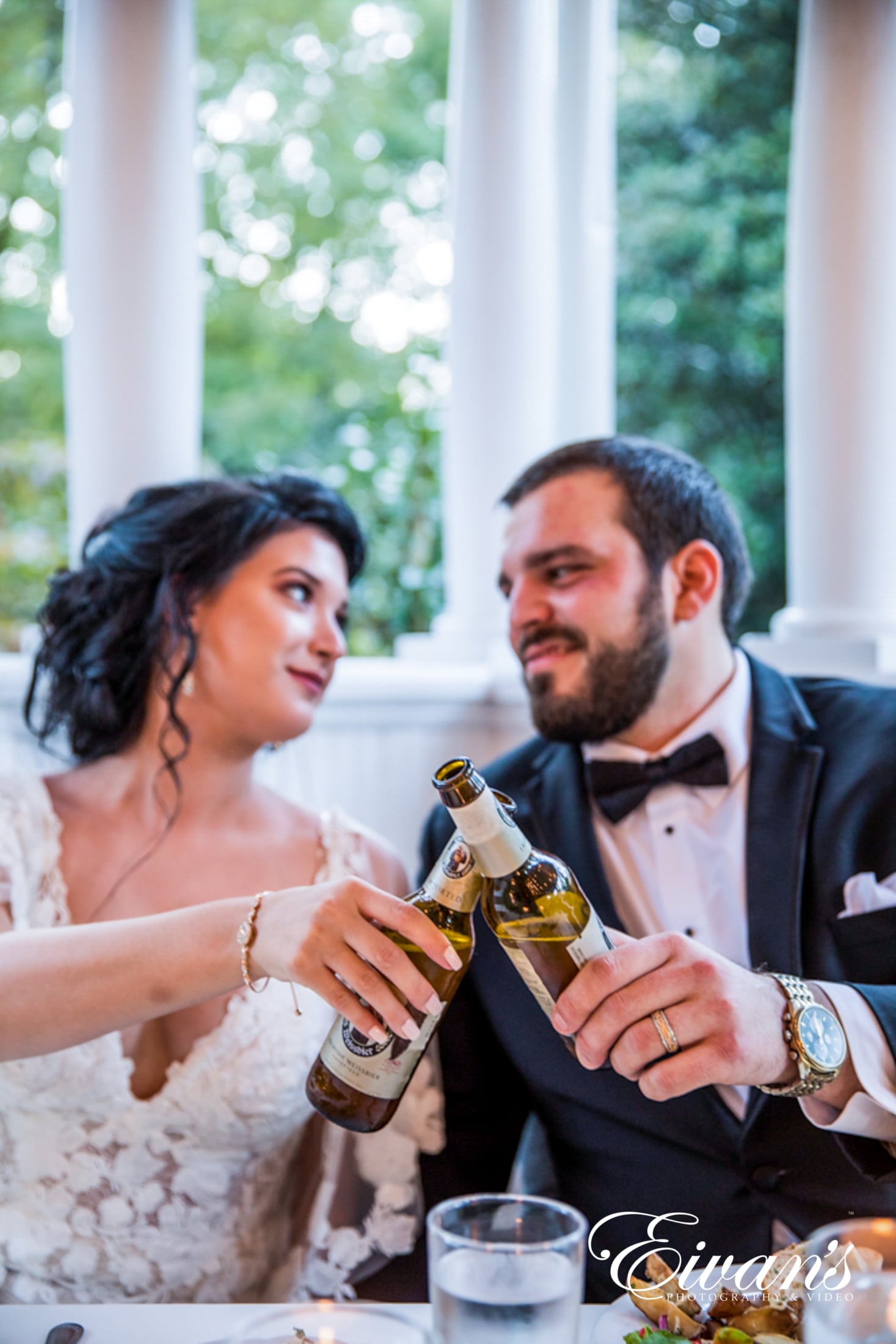 how-to-have-a-minimalist-wedding image of a bride and groom cheering a beer