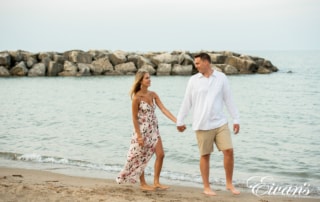 image of engaged couple walking on the beach