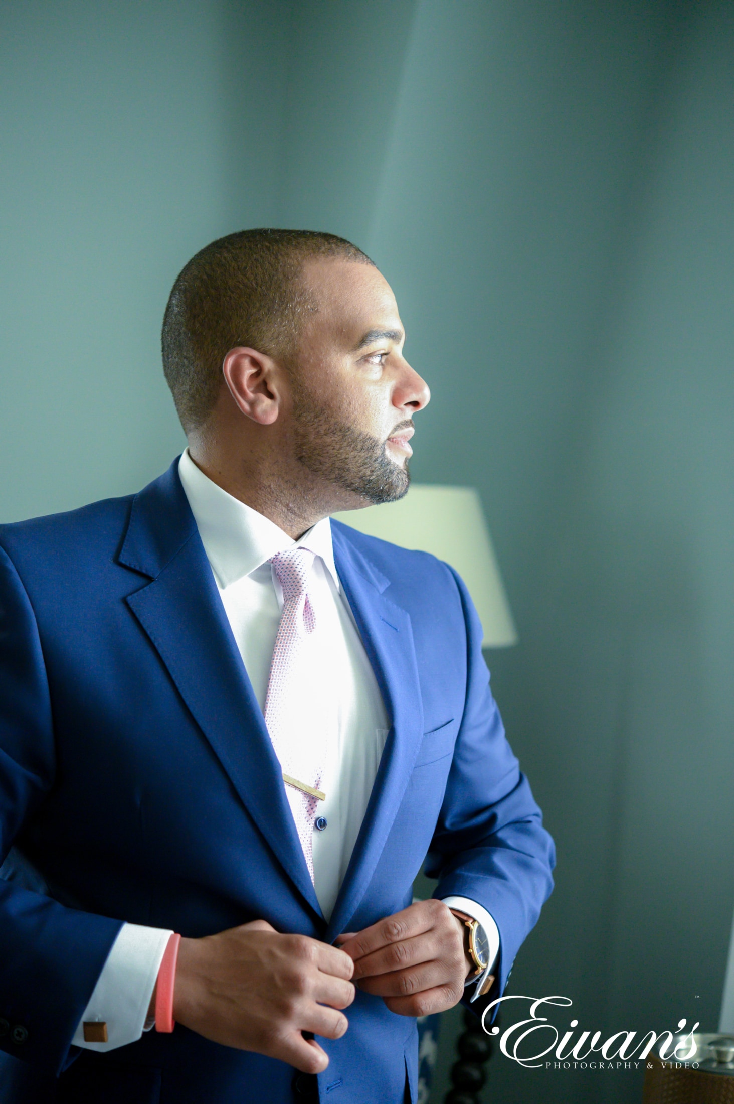 image of a groom on his wedding day looking out the window