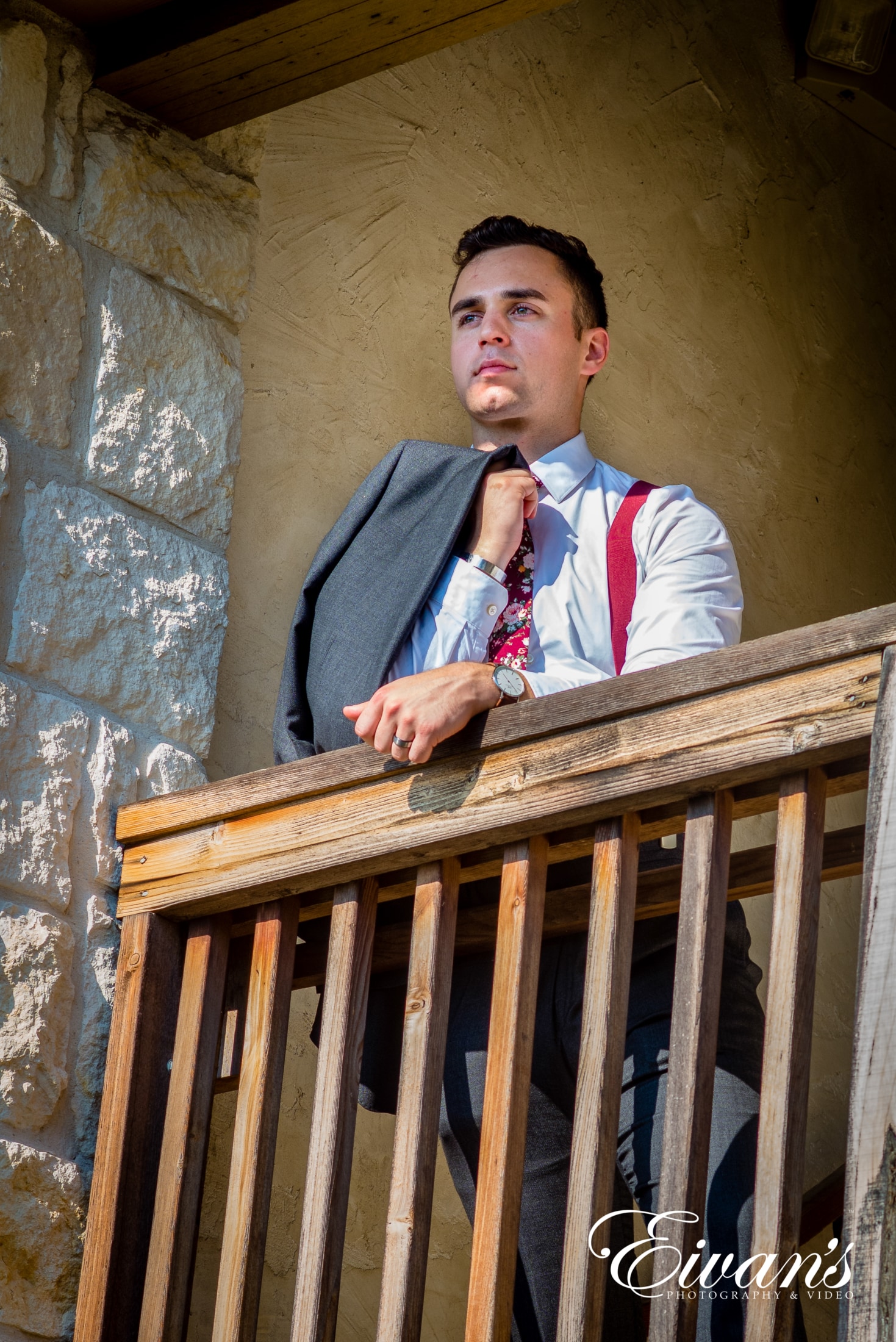 image of a groom looking off the balcony