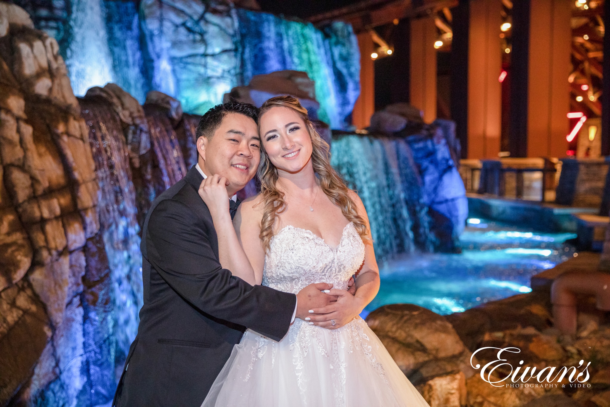 image of a married couple hugging in front of a waterfall