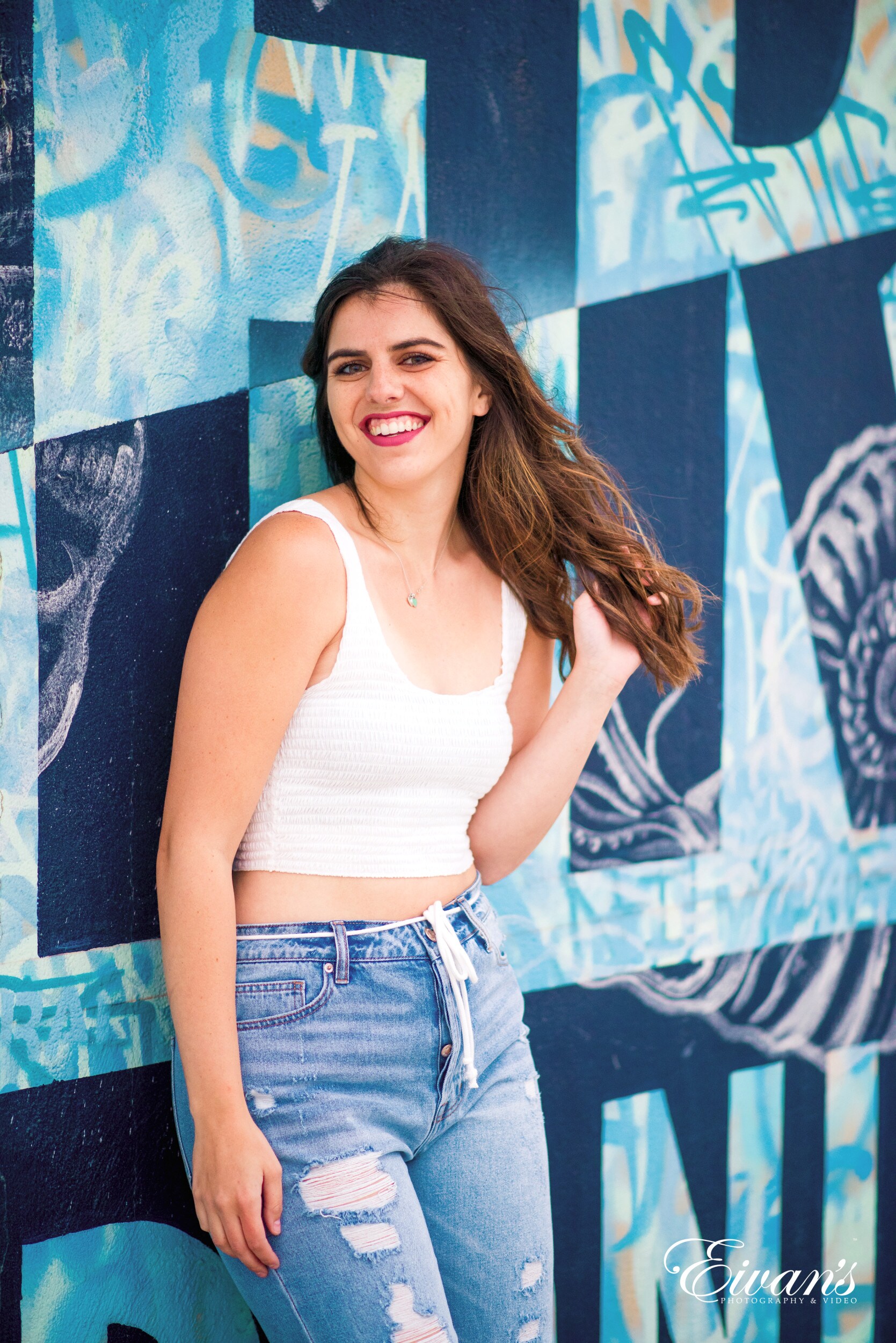 woman in white tank top and blue denim shorts smiling