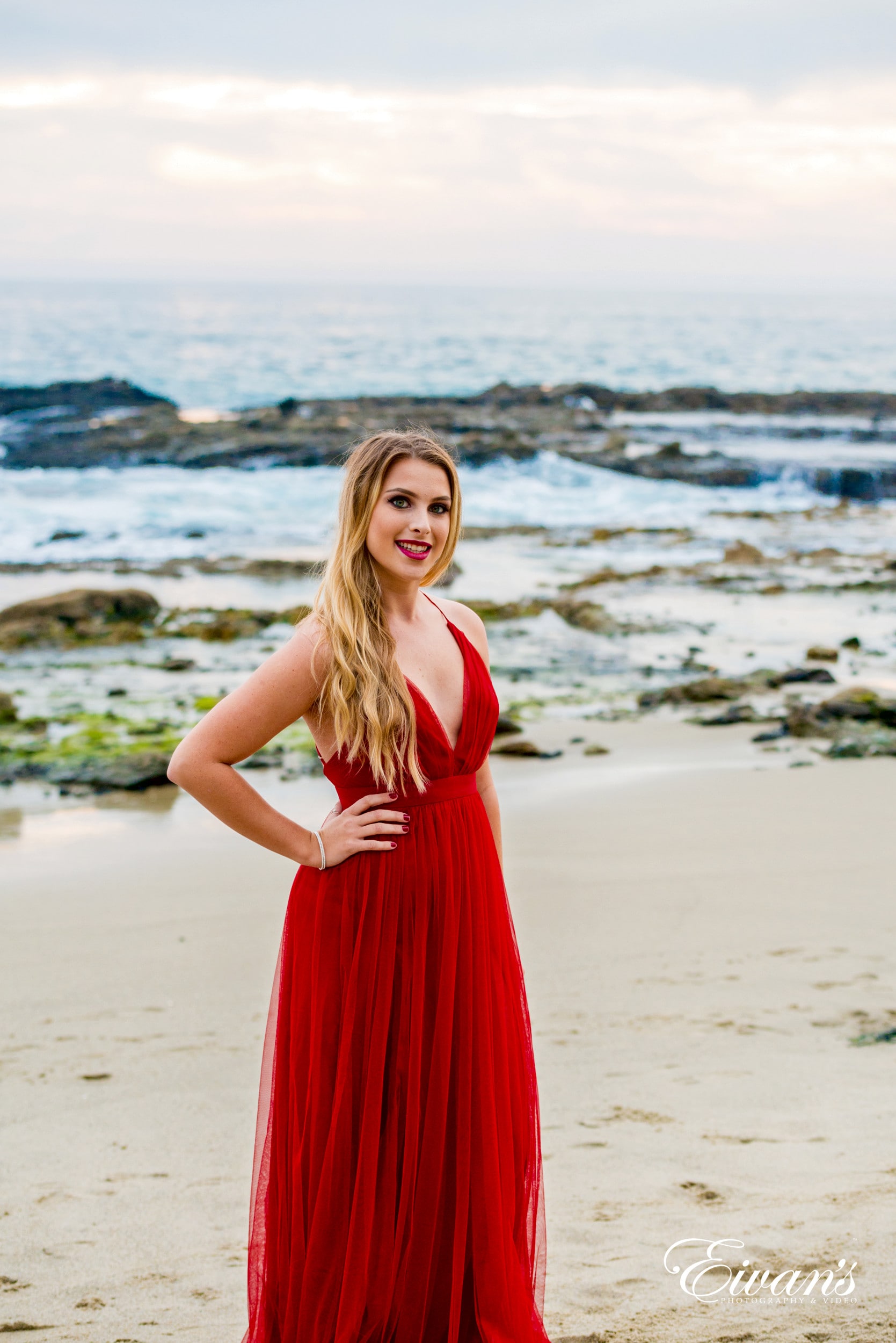 woman in red sleeveless dress standing on beach during daytime