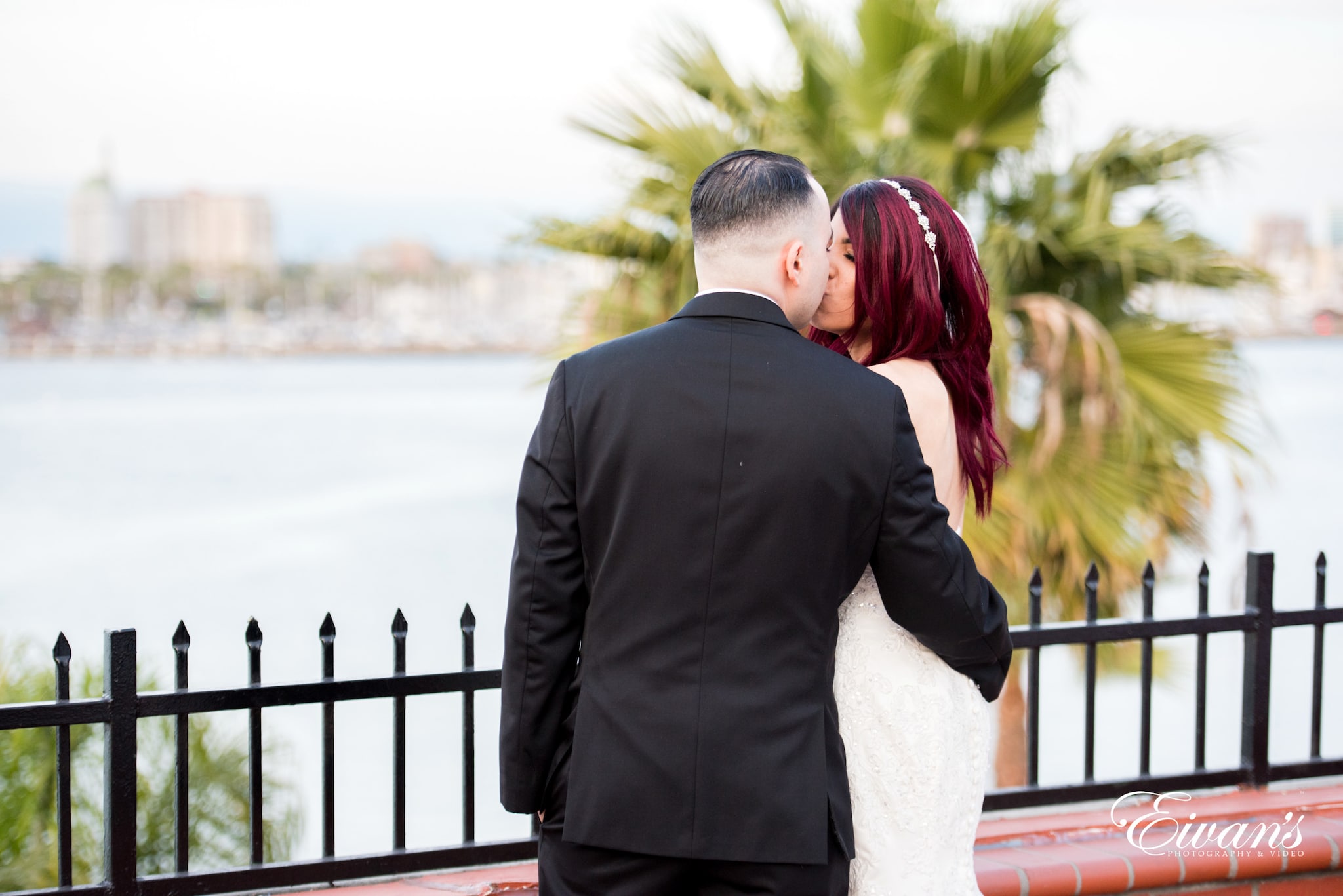 man in black suit jacket hugging woman in white dress