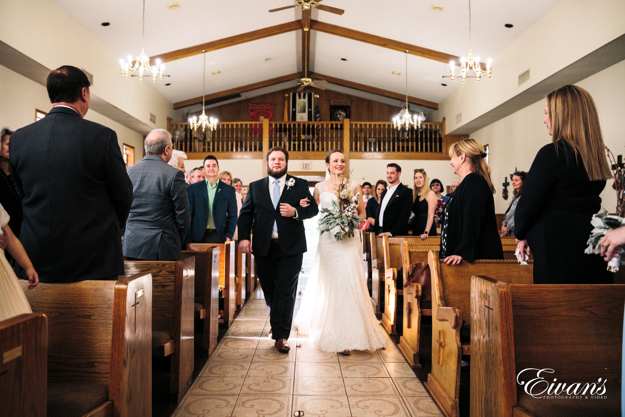 man in black suit jacket standing beside woman in white wedding gown