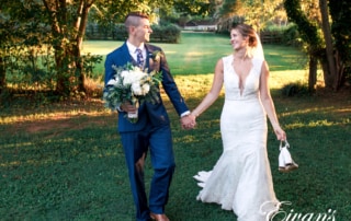 man in black suit and woman in white wedding dress holding bouquet of flowers