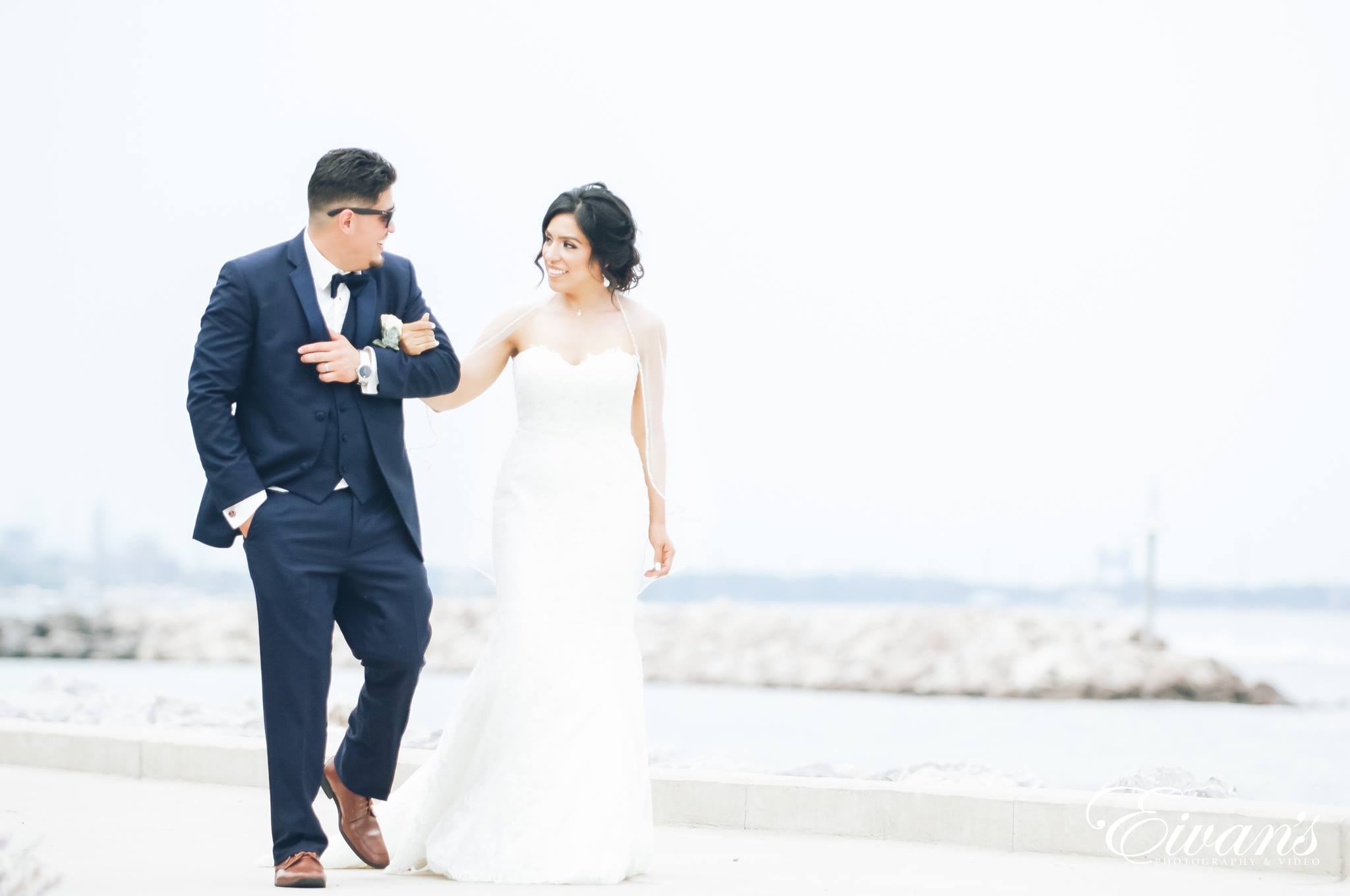 man in black suit and woman in white wedding dress