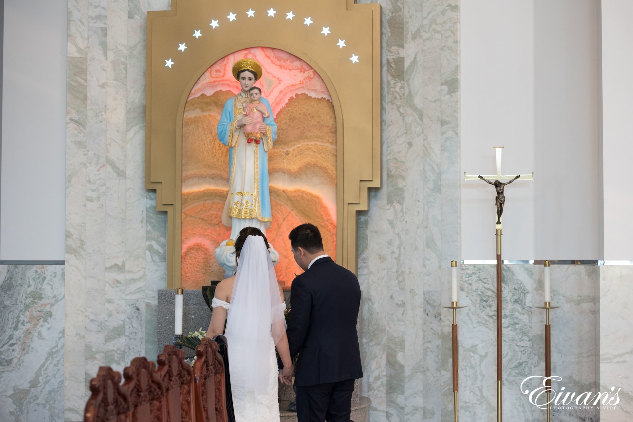 man in black suit standing beside woman in white dress