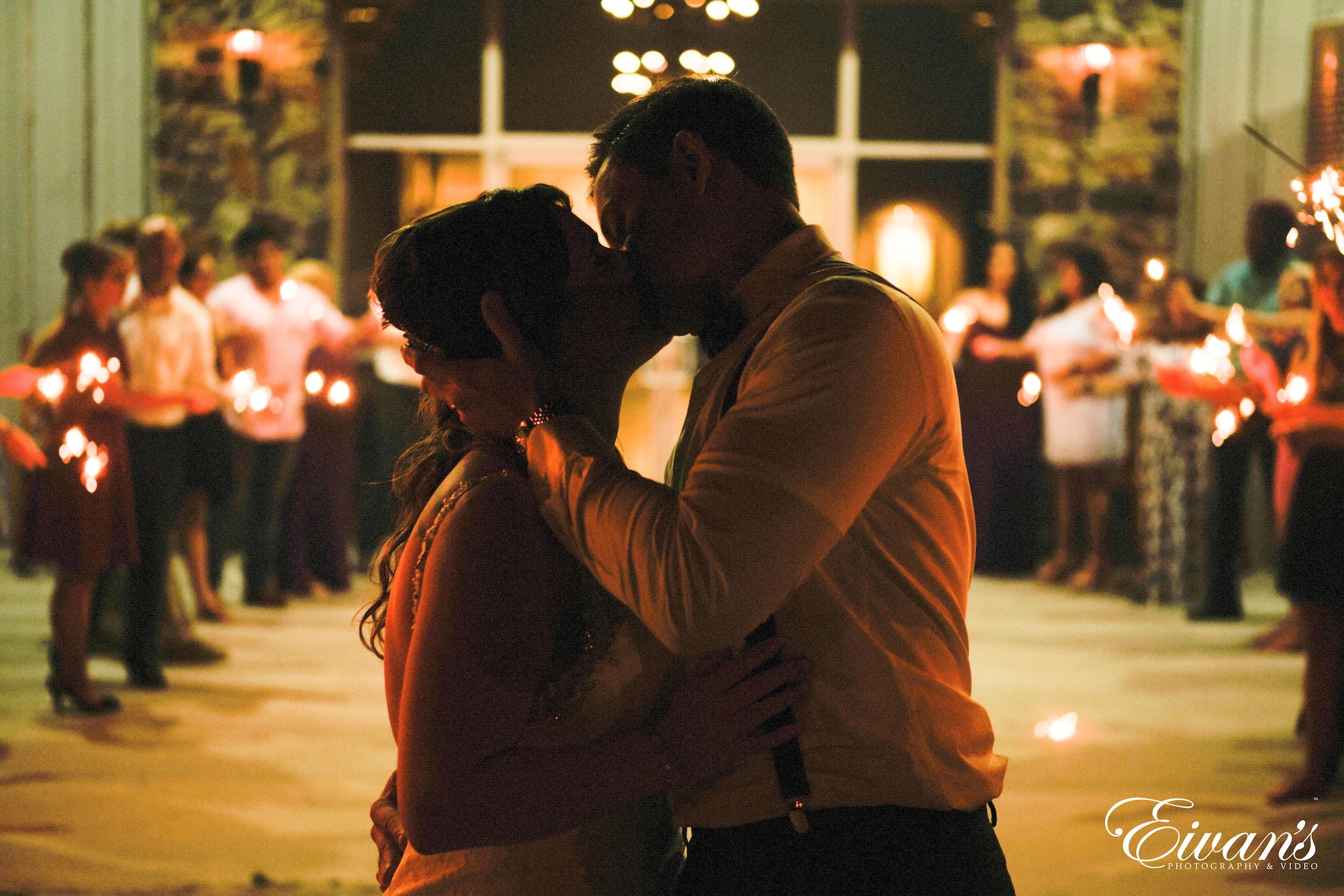 man and woman kissing at the end of their reception