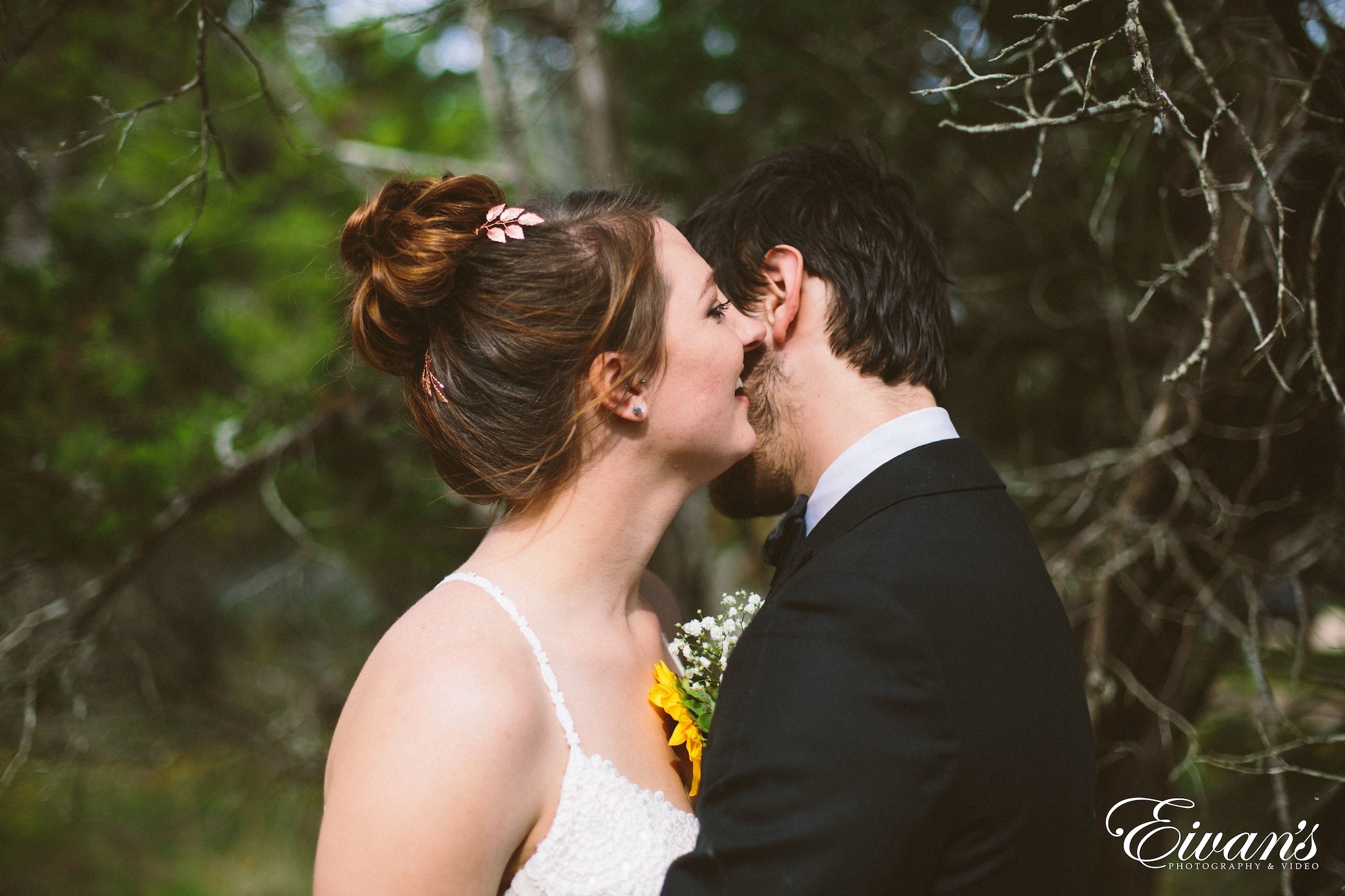 man in black suit kissing woman in white wedding dress