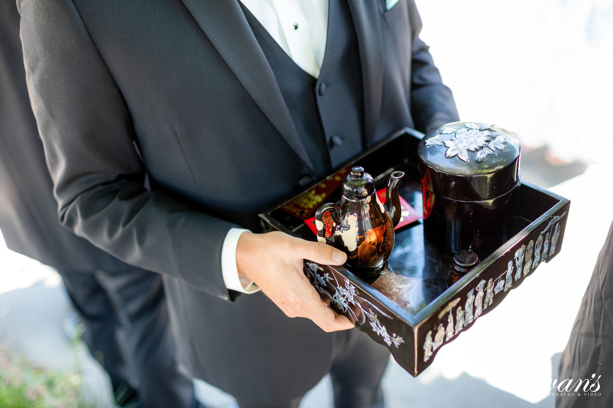 man in black suit jacket holding silver trophy