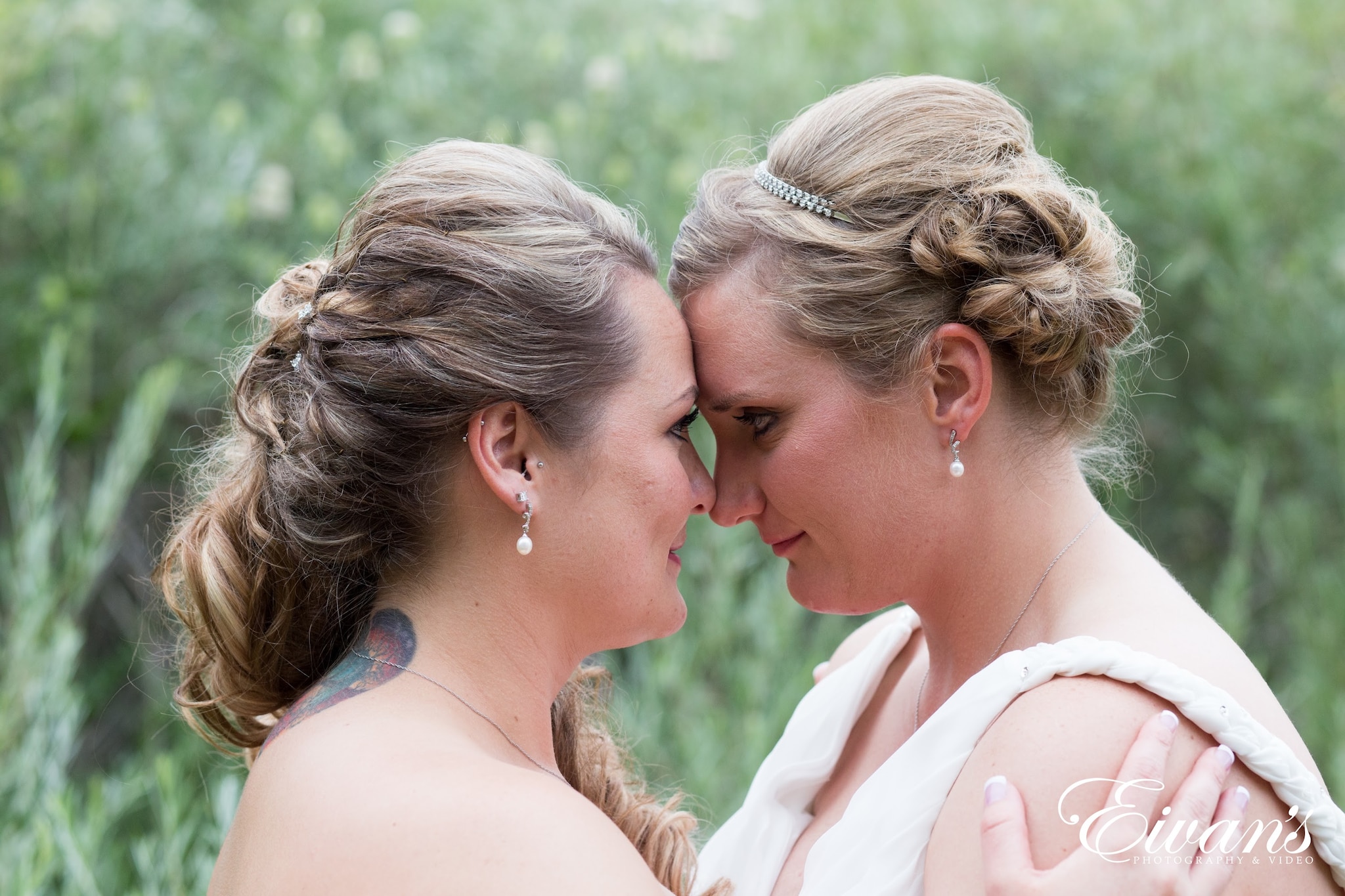 woman in white sleeveless dress kissing woman in white sleeveless dress