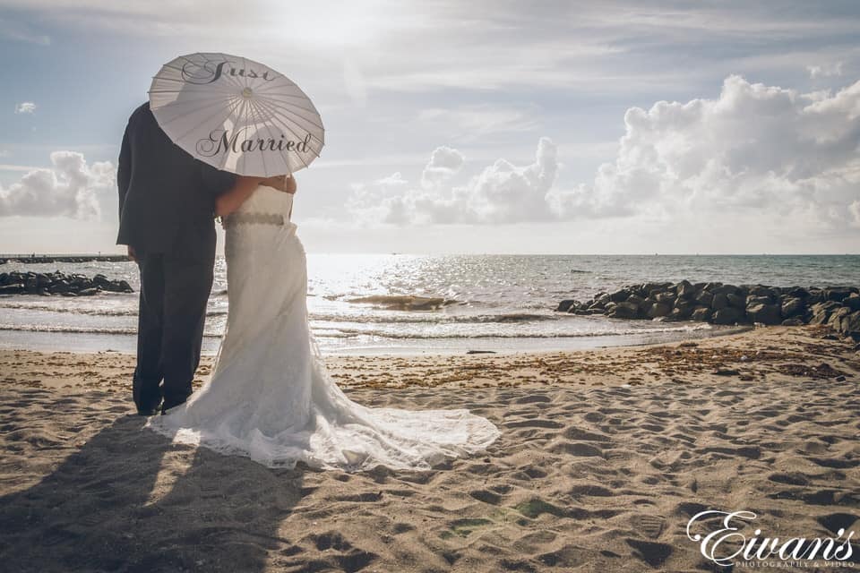 woman in white wedding dress standing on beach during daytime