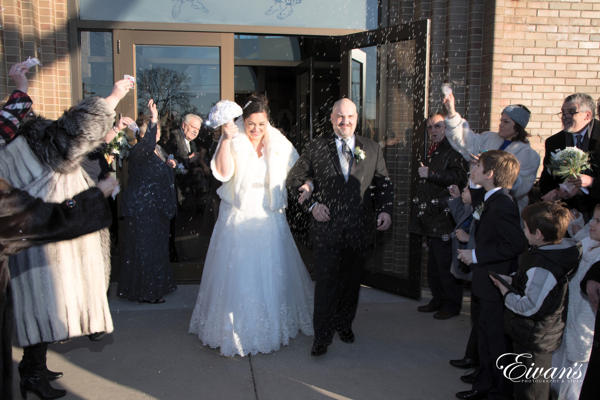 man in black suit standing beside woman in white wedding dress