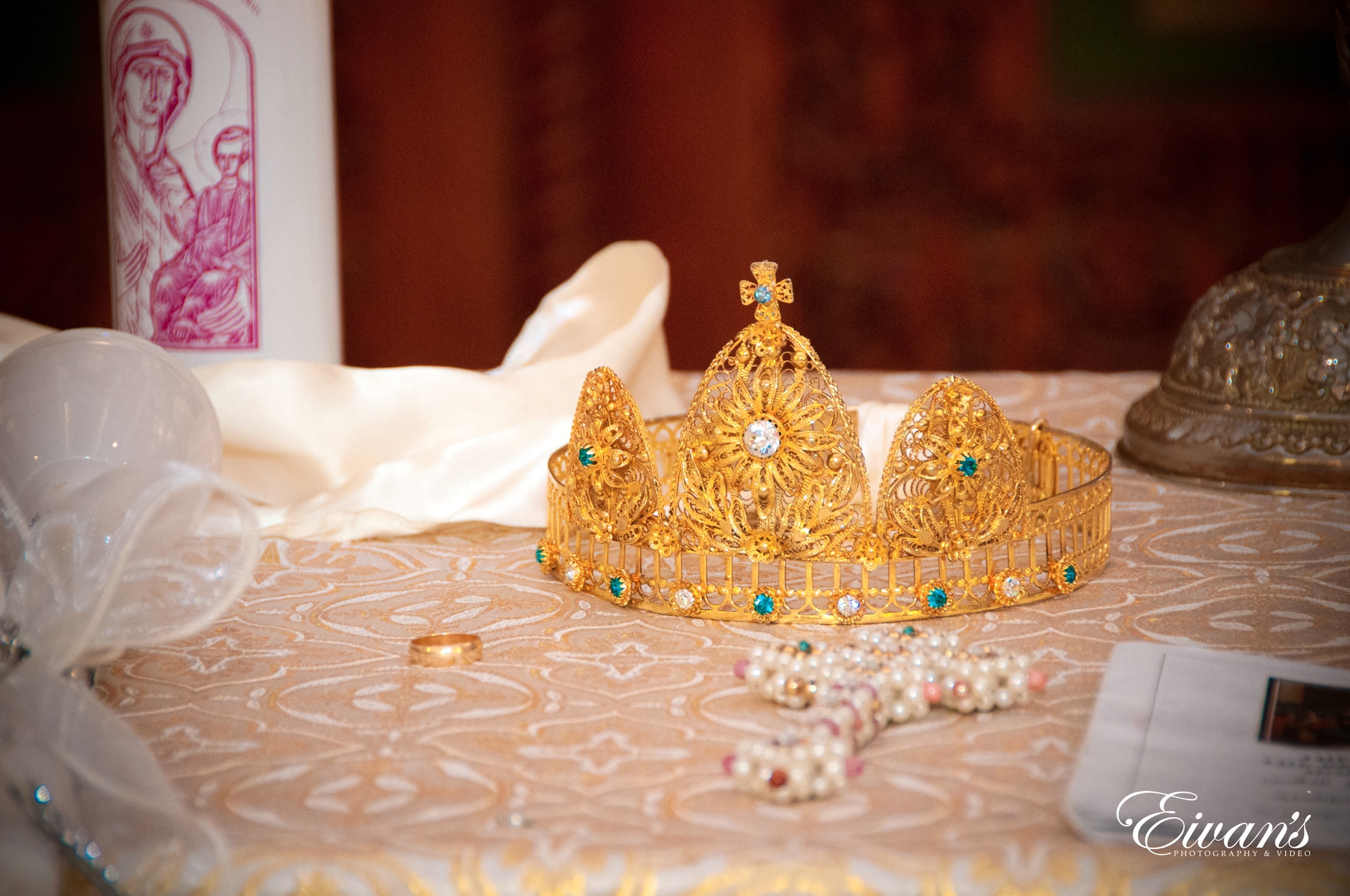 gold and white crown on white textile