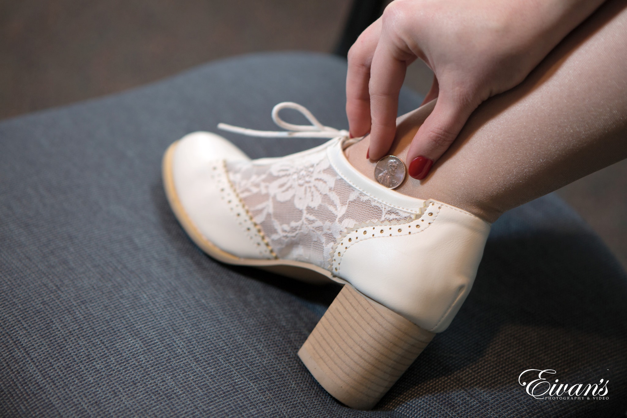 person holding white floral lace up shoe