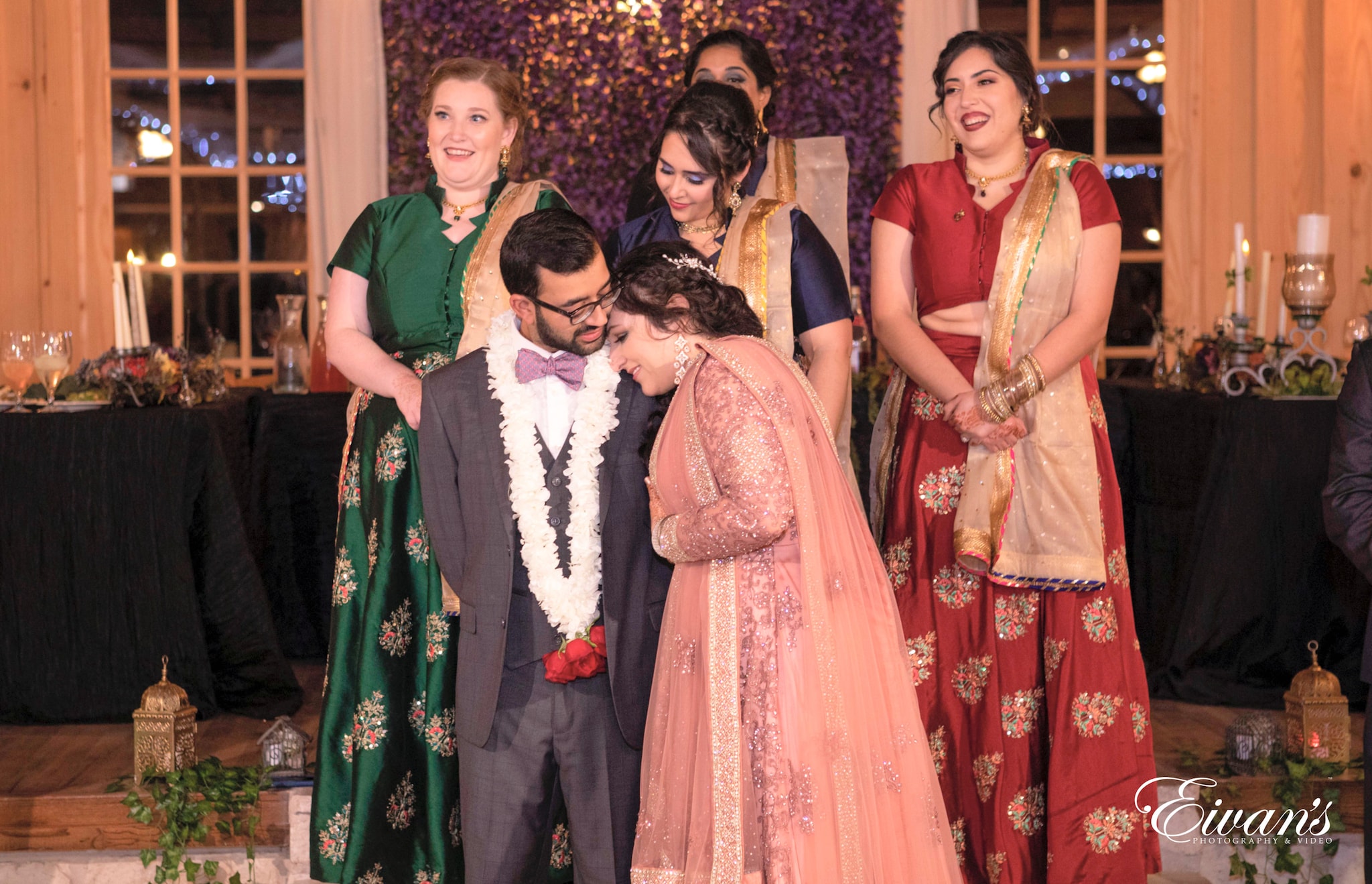 woman in red and gold sari standing beside woman in green and brown sari