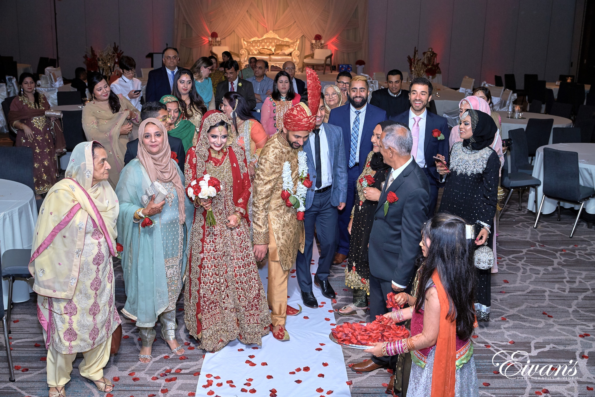 group of people standing on red and white floral carpet