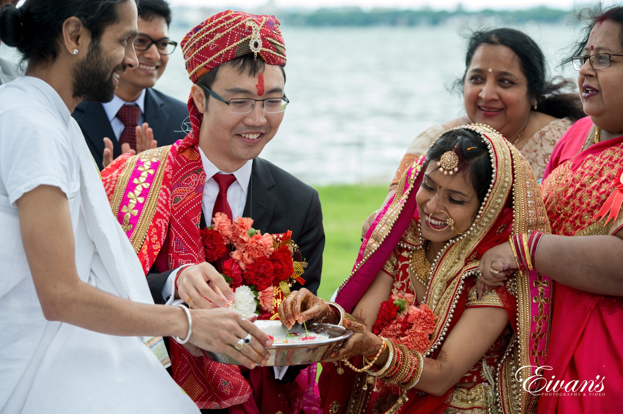 woman in red and gold sari holding bouquet of flowers